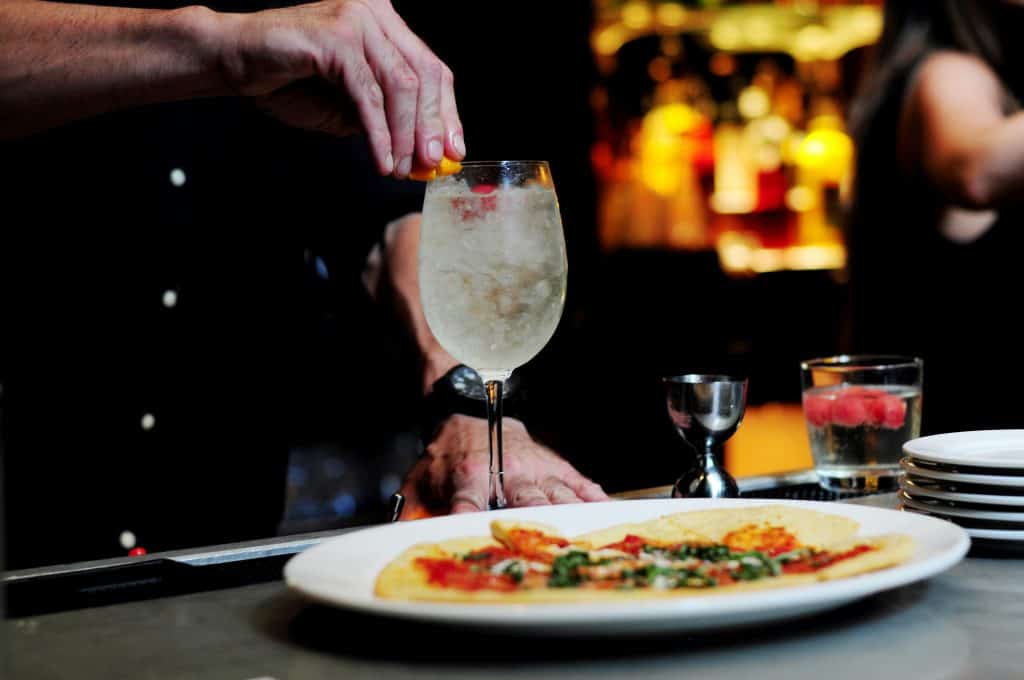 Cocktails and freshly prepared food on a restaurant table during an evening meal in the Cayman Islands, highlighting late night dining.