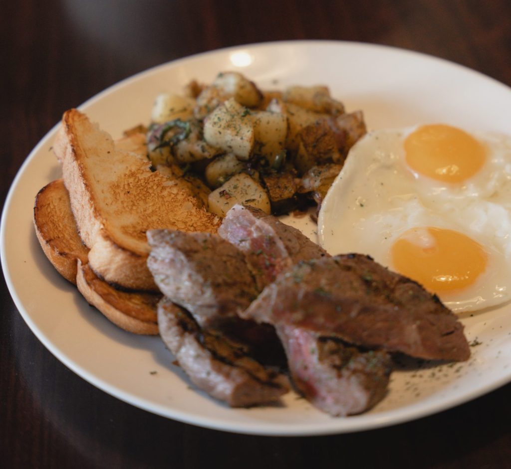 Steak & eggs served for breakfast at a Cayman Islands restaurant, highlighting weekday breakfast options before work or meetings.